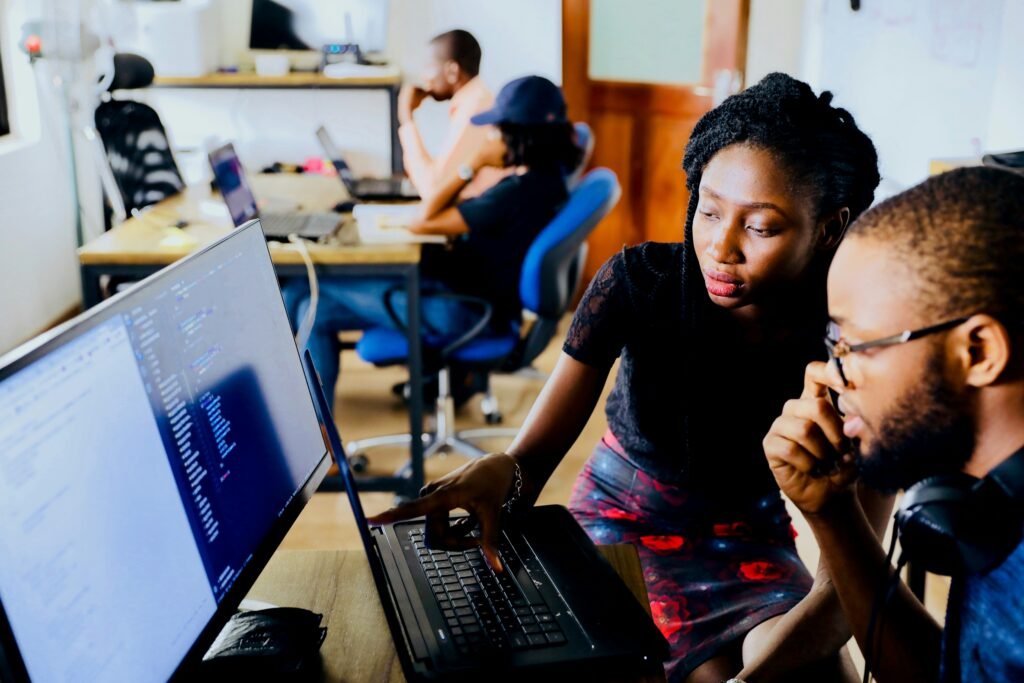 woman helping someone use the computer