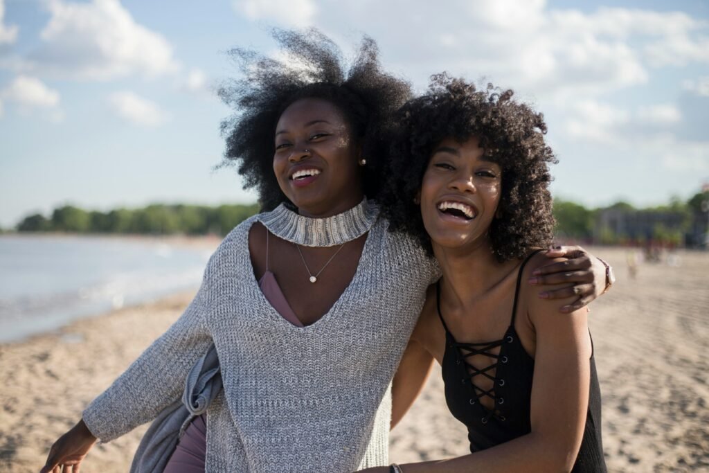 two black woman smiling and side hugging